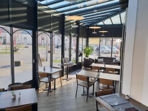 永河畔拉罗什Hôtel de la Gare - Restaurant Bistro Quai的餐厅设有桌椅和窗户。
