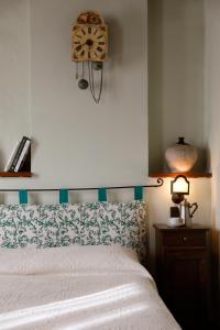 乌尔巴尼亚Agriturismo Valpietro的卧室配有一张床,墙上挂着一个钟