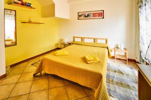 萨包迪亚Arcibaleno的一间卧室配有一张带两张黄色毛巾的床