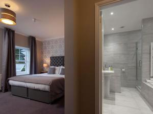 普里茅斯艾尔夫德雷酒店的一间卧室配有一张床,浴室设有淋浴。