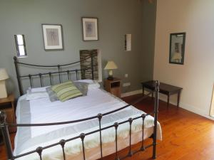 舒尔河畔卡里克The Old House的一间卧室配有一张带白色床单和桌子的大床