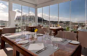 雅典Elia Ermou Athens Hotel的用餐室设有桌椅和窗户。