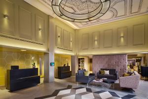 伦敦馨塔迪特拉法加广场酒店的一个带沙发和椅子的大堂和天花板