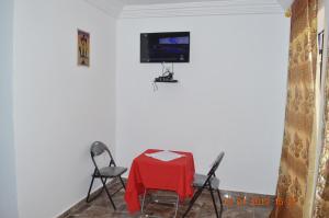 班珠尔Sukuta Nema Guest House的一间配备有桌子和两把椅子及一台电视的房间