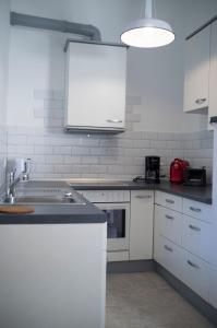 杜塞尔多夫Quadenhof的厨房配有白色橱柜和水槽