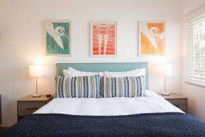 恩西尼塔斯Surfhouse的卧室配有一张墙上三幅照片的床