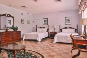 克劳福德维尔The Lodge at Wakulla Springs的一间卧室配有两张床、一张桌子和一面镜子