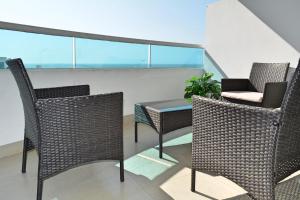 卡塔赫纳Torres del Lago Apartamentos的阳台配有两把椅子和一张桌子,位于屋顶