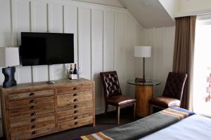 塔霍城桑尼塞得度假小屋酒店的一间卧室配有一台电视,在一个带两把椅子的梳妆台上