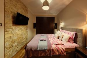 卡托维兹Apartament MODERNA Francuska Park的一间卧室配有一张石墙床