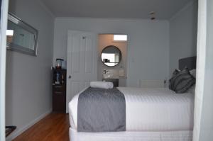 国家公园汤加里罗温泉精品汽车旅馆的卧室配有白色的床和镜子