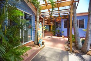 麦夸里港奥齐波茨背包客 - 麦觉理港国际青年旅舍的庭院里种有棕榈树和冲浪板的房子