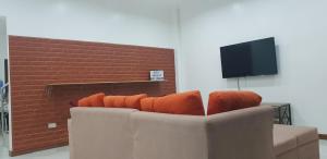 公主港KDC Homes (Gold)的客厅里配有带橙色枕头的沙发