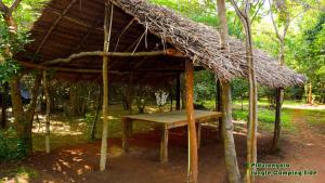 锡吉里亚Sigiri Jungle Camping的小屋,带桌子和草屋顶