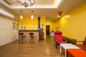 宜兰市夜市橙堡渡假旅馆的客厅设有黄色墙壁和红色椅子