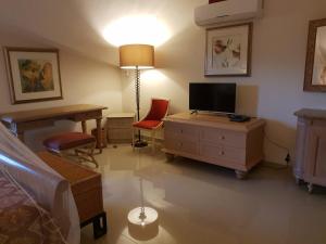 Post of FlacqShanti Nivas的客房设有带书桌和电视的卧室。