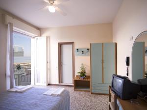 里米尼特尔斯塔酒店的一间卧室设有一张床、一台电视和一个窗口。