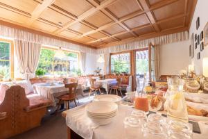新黎凡特Haus Christian的餐厅设有白色的桌椅和窗户。