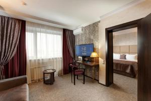 莫斯科Hotel Salut的配有一张床和一张书桌的酒店客房