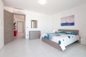 卡普多兰多Il Gabbiano - Case Vacanze的白色卧室配有一张带蓝色枕头的大床