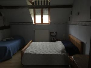 Biernegite du chêne的一间卧室设有两张床和窗户。