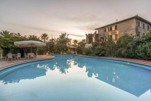 马里纳迪马萨马雷蒙帝别墅酒店的一个带桌子和遮阳伞的游泳池