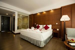 博卡拉Himalayan Front Hotel by KGH Group的卧室配有带红色枕头的大型白色床