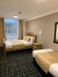 丁沃尔Waverley Inn Lodge的酒店客房设有两张床和窗户。