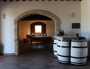 蒙特法尔科Casale Rialto的一间带桌子和酒桶的用餐室