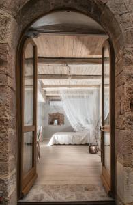 CrocemaroggiaIl Castello Di Perchia的拱门通往卧室,卧室配有床