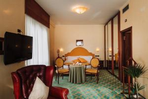 基安奇安诺泰尔梅怡东大酒店的酒店客房配有一张床铺和一张桌子。