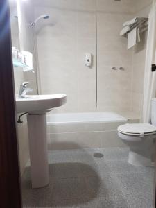 莱佩拉诺里亚酒店的浴室配有盥洗盆、卫生间和浴缸。