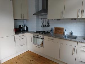 多德雷赫特Hiltje - Nice to stay的厨房配有白色橱柜和炉灶烤箱。