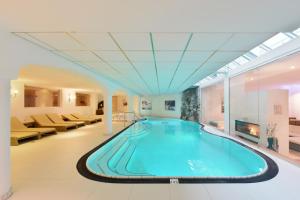 蒂罗尔-泽费尔德Mountains Hotel的酒店大堂的大型游泳池