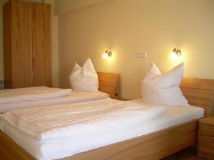 SalzkottenHotel-Restaurant Sälzerhof的配有白色枕头的酒店客房内的两张床