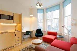 伦敦Kensington Stay的客厅配有红色沙发和红色椅子