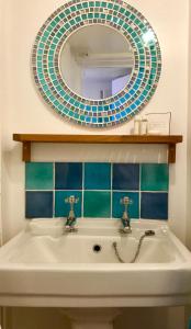 帕兹托Cyntwell Guest Accommodation的一间带水槽和镜子的浴室