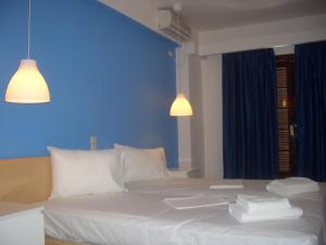 阿吉亚玛丽娜蓝泉酒店的卧室配有白色床和蓝色墙壁