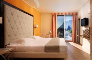 加尔达湖滨托奈利克里斯塔尔皇宫酒店的一间带大床的卧室和一个阳台