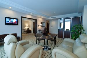 罗兹国宾中心酒店的酒店客房设有沙发、桌子和椅子。