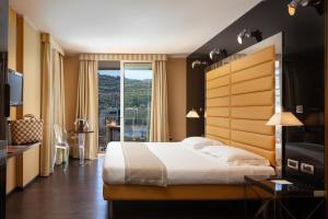 加尔达湖滨托奈利克里斯塔尔皇宫酒店的一间卧室设有一张大床和一个大窗户
