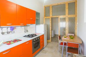 马泰拉维拉住宿加早餐旅馆的厨房配有橙色橱柜、桌子和炉灶。
