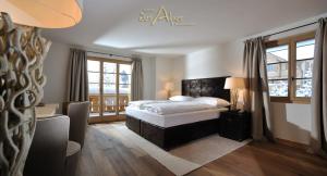格施塔德Hotel des Alpes Superieur的一间卧室设有一张床和两个窗户。