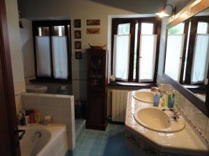 AmandolaVilla Arzilla的浴室配有2个盥洗盆、浴缸和浴缸。