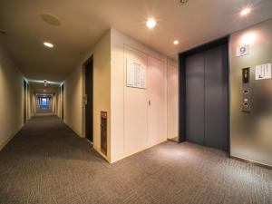 高松Super Hotel Takamatsu Tamachi的走廊,带走廊的办公大楼走廊