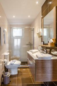 阿齐亚佩拉加佩拉梅尔公寓式酒店的一间带卫生间、水槽和镜子的浴室