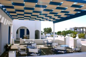 卡马利Blue Bay Villas的蓝色天花板下带桌椅的庭院