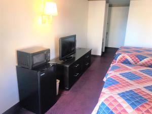 阿尔伯克基American Inn & Suites的酒店客房设有电视和床。