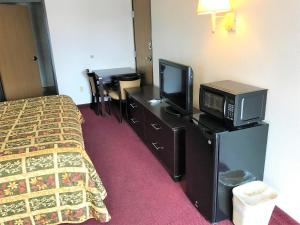 阿尔伯克基American Inn & Suites的一间酒店客房,配有一张床和一台电视