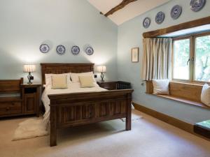 WhitbeckThe Wayside and Whisky Barn的卧室配有一张床,墙上挂着蓝色的盘子